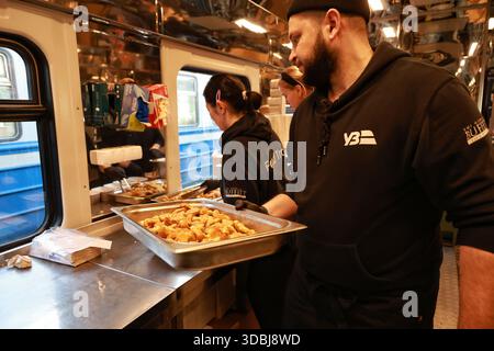 Non esclusivo: Volontari del treno alimentare, che fornisce pasti caldi a persone senza alimentazione e riscaldamento a causa di un attacco russo, pranzo al sacco Foto Stock