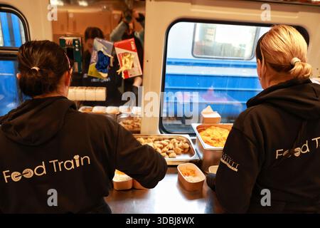 Non esclusivo: Volontari del treno alimentare, che fornisce pasti caldi a persone senza alimentazione e riscaldamento a causa di un attacco russo, pranzo al sacco Foto Stock