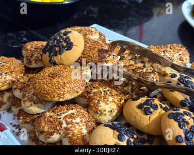 Panini assortiti e pasticcini con semi disposti sul vassoio da portata Prodotti da forno, servizio colazione, cibi carboidrati e prodotti da forno freschi Foto Stock