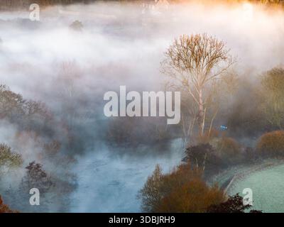 Veduta aerea di un tranquillo paesaggio dove il fiume si snoda tra gli alberi, la nebbia è appesa all'aria fredda, Thames Valley, Oxfordshire, United Kin Foto Stock