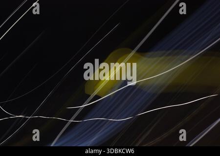 Uno sfondo astratto minimalista con striature chiare chiare chiare chiare e nitide in bianco e giallo su uno sfondo scuro. Foto Stock