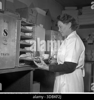 Cibo per aerei in preparazione 1951. Si vede una donna che rifornisce il contenitore SAS con i vassoi di cibo. I container saranno quindi caricati a bordo dell'aereo. Si tratta di un servizio a terra in aeroporto con il cibo e le bevande che poi viene servito sull'aereo commerciale SAS 1951. Conard rif. 1854 Foto Stock