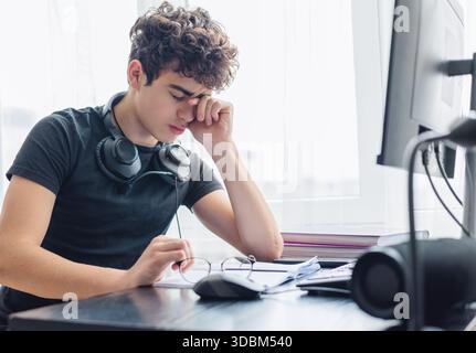 Studente stressato. Studia Burnout. Sopraffatto. Ansia. Affaticamento mentale. onlinelearning. Adolescente sopraffatto che lotta con lo studio e l'esame StRe Foto Stock