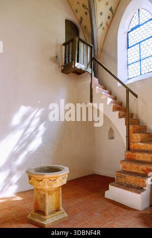 Fonte battesimale gotica e scalinata per la galleria all'interno della chiesa parrocchiale di San Vito, Leipheim, Svevia Bavarese, Svevia, Baviera, Germania Foto Stock