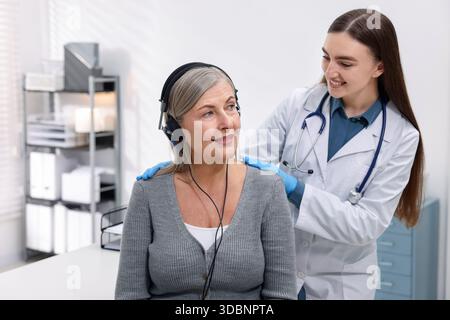 Paziente con cuffie audiometriche sottoposto a test uditivo in clinica Foto Stock