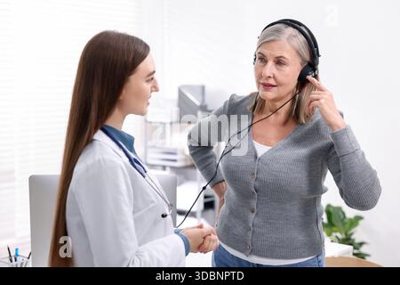 Paziente con cuffie audiometriche sottoposto a test uditivo in clinica Foto Stock