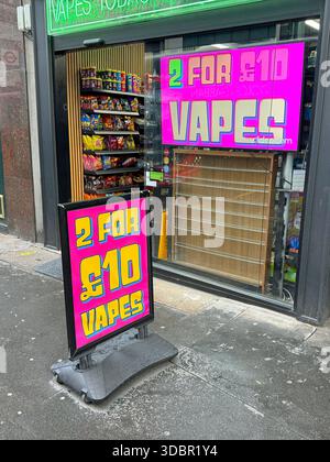 Londra, Regno Unito - 29 ottobre 2024: Di fronte a un negozio di fumi elettronici e vape e a un annuncio pubblicitario. Foto Stock