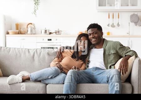 Una coppia amorevole condivide un momento di gioia sul divano del soggiorno Foto Stock