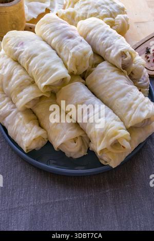 Processo di preparazione di involtini di cavolo ripieni fatti in casa con carne macinata, riso e spezie in un'accogliente cucina casalinga. Tradizionale preparazione di cibi confortevoli Foto Stock