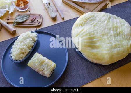 Processo di preparazione di involtini di cavolo ripieni fatti in casa con carne macinata, riso e spezie in un'accogliente cucina casalinga. Tradizionale preparazione di cibi confortevoli Foto Stock