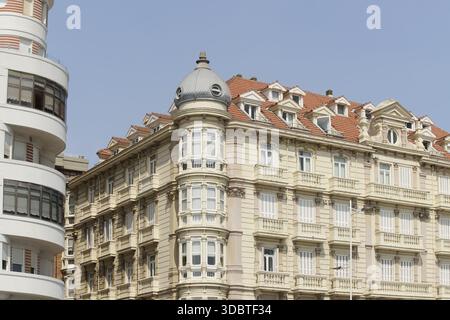 Vista di edifici ornati con tetti di tegole rosse e finestre a bovindo arrotondate si stagliano maestosamente contro un cielo limpido, eleganza architettonica, Santander, Canta Foto Stock