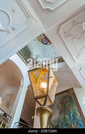 Sigmaringen, Germania - 09 settembre 2025: Vista dell'interno del castello di Hohenzollernschloss con una lanterna decorata appesa sotto uno splendido decoro Foto Stock