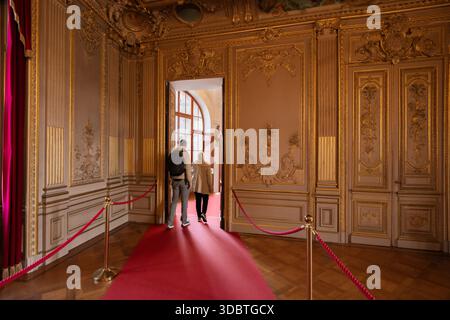 Sigmaringen, Germania - 09 settembre 2025: Vista dell'interno del castello di Hohenzollernschloss, dove dettagli in oro ornato contrastano con il ricco tappeto rosso Foto Stock