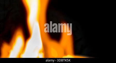 Fiamme fiamme sfocate astratte in arancione e bianco acceso su sfondo nero. Effetto bokeh ad alto contrasto che crea un ambiente caldo ed energico Foto Stock