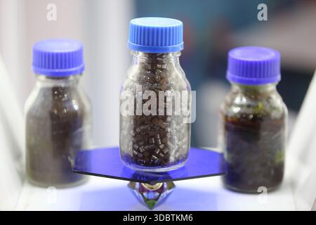 Pellet catalizzatore nero in un contenitore di vetro Foto Stock