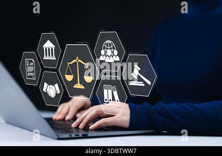 Concetto di diritto digitale e consulenza legale. Una persona che lavora su un laptop con icone virtuali bilance legali, un tribunale, un martelletto, documenti, stretta di mano a Foto Stock