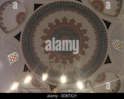 Cupola ottomana decorata con calligrafia araba e lampadario sospeso in una moschea di Istanbul Foto Stock