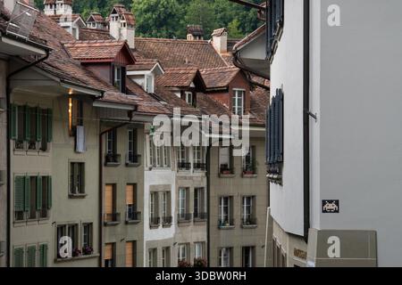 Edifici della città vecchia di Berna con tetti in terracotta, finestre dormitori e un mosaico Space Invader su una facciata bianca Foto Stock