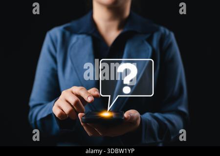 Icona del punto interrogativo sopra lo smartphone che rappresenta il concetto di FAQ. Donna interagisce con lo schermo luminoso dello smartphone e con l'icona del punto interrogativo digitale, Foto Stock
