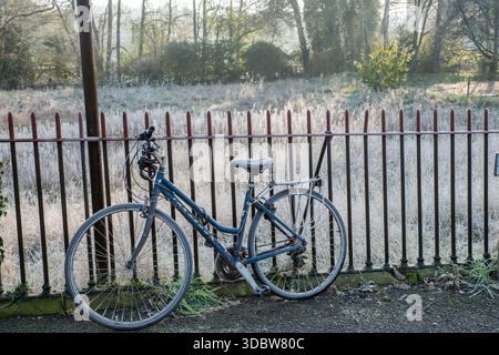 Una bicicletta ricoperta di gelo incatenata alle ringhiere su un moring freddo a Belper, Derbyshire, East Midlands, Inghilterra Foto Stock