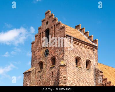 Cima della torre Sankt Laurentii Kirke con sezione orologio in mattoni e timpano a gradini nel centro storico di Kerteminde, Funen, Danimarca meridionale Foto Stock