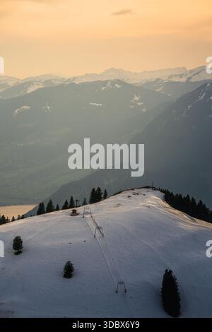 Vista della vetta innevata sotto il caldo bagliore del sole che tramonta, con Alpi lontane avvolte dalla nebbia morbida, Rigi Kulm, Lucerna, Canton Lucerna, Foto Stock