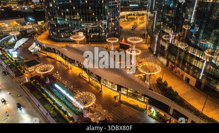 Vista aerea del ponte pedonale illuminato in contrasto con le torri di vetro scuro e i vivaci lampioni, Hyderabad, Telangana, India. Foto Stock