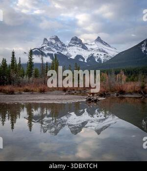 Spettacolare riflesso delle montagne delle tre Sorelle, un trio di tre cime vicino alla città di Canmore, in Alberta, Canada Foto Stock