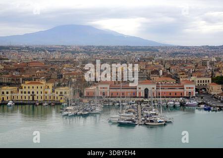 Ammira Catania in Sicilia, Italia, con il vulcano Etna, che domina l'orizzonte in una giornata nuvolosa Foto Stock