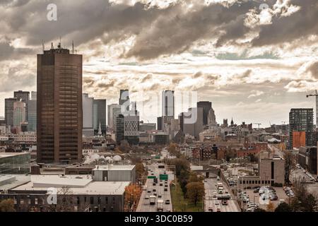 Skyline del centro di Montreal, Quebec, Canada, con le autostrade di Avenue Viger e Ville Marie piene di traffico intenso che conducono verso gruppi di Foto Stock