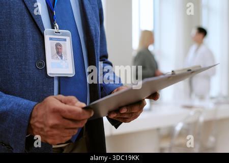 Uomo di mezza età che tiene gli appunti in ambiente moderno di Medical Office Foto Stock