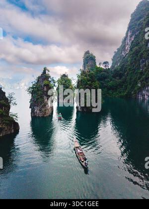Esplorate la tranquilla bellezza del lago Cheow LAN a Khao Sok, Thailandia. una coppia che guarda l'alba su una barca a coda lunga Foto Stock