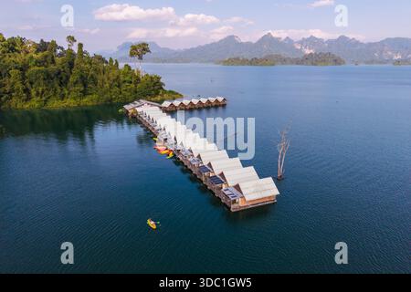 Esplora la tranquilla bellezza del lago Cheow LAN a Khao Sok, Thailandia, dove i kayak colorati scivolano sulle acque cristalline, circondati da lussureggianti mou verdi Foto Stock