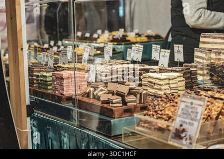 Rovigo, italia, 18 dicembre 2025: Cioccolato artigianale e dolci esposti in un vivace mercato, colorate confetture fatte a mano che invitano gli acquirenti Foto Stock