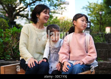 Madre e figlie giapponesi che si divertono nel parco Foto Stock