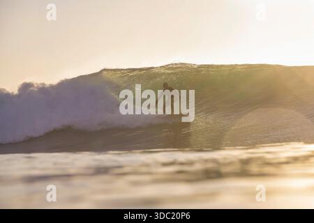 Surfista all'interno della barreling Wave che illumina la luce compressa Foto Stock