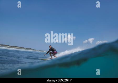 Scultura del surfista su un viso a onda aperta, scatto diviso Foto Stock