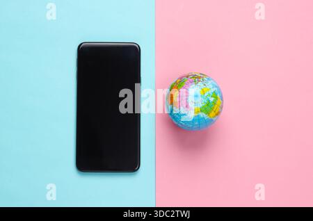 Smartphone e globo su sfondo blu rosa. Rete globale. Comunicazioni mobili in tutto il pianeta. Rete globale 5G. Foto Stock