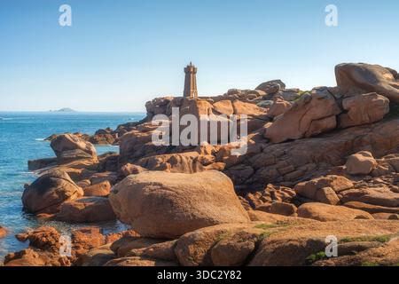 L'iconico faro di Mean Ruz si erge tra massi di granito rosa a Ploumanac'h.. Scenografico punto di riferimento costiero in Bretagna, Francia Foto Stock