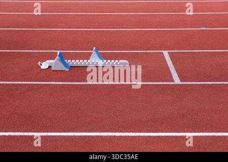 Un blocco di partenza su una pista di atletica leggera Foto Stock