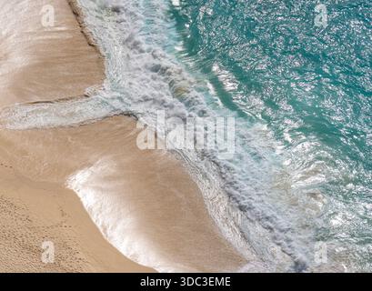 Vista aerea dall'alto verso il basso di una spiaggia con delicate onde bianche spumose foto di alta qualità Foto Stock