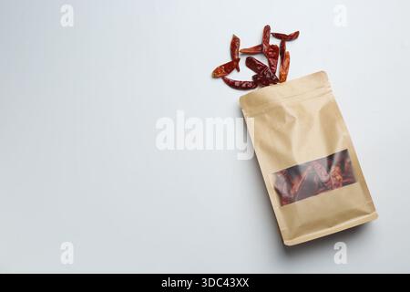 Custodia in piedi con peperoncino essiccato su sfondo chiaro, vista dall'alto. Spazio per il testo Foto Stock