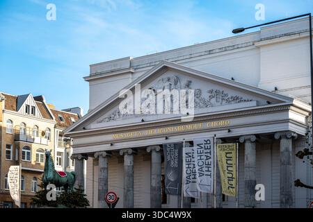 Aquisgrana, Germania - 4 dicembre 2025: Facciata neoclassica del Teatro di Aquisgrana con frontone e colonne scolpite, vista alla luce del giorno con striscioni e surr urbano Foto Stock