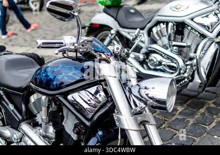 Motocicletta personalizzata Harley-Davidson con vernice blu fiamma e faro cromato parcheggiata al rally motociclistico di Varsavia. Foto Stock