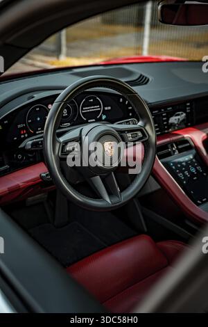 Interni moderni con interni rossi e neri che mostrano volante e strumenti, Porsche Taycan, Deer Carsharing, Calw, Germania Foto Stock