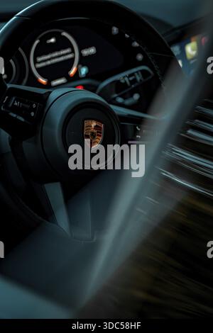 Primo piano di un volante moderno con tachimetro e indicatori LED in un'auto, Porsche Taycan, Deer Carsharing, Calw, Germania Foto Stock