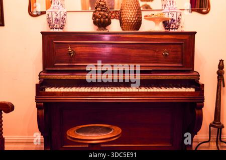 Un classico pianoforte in legno, visto in un'ampia vista, colorato e in ottime condizioni e conservato. Installato in un palazzo classico, pronto a giocare, Foto Stock
