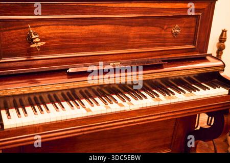 Un classico pianoforte in legno, visto in un'ampia vista, colorato e in ottime condizioni e conservato. Installato in un palazzo classico, pronto a giocare, Foto Stock