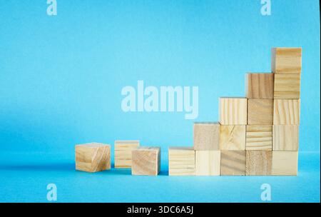 business concept, blocchi di legno come scala piramidale su sfondo blu. Il successo, l'innovazione, la crescita, il successo, lo sviluppo o il concetto di top ranking Foto Stock