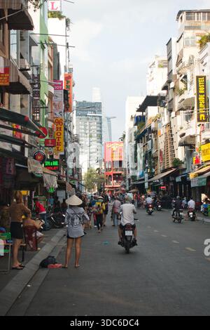 HANOI-Vietnam-18 agosto 2019, Una strada affollata e vivace piena di pedoni, moto, hotel, bar e insegne al neon, tipico del popolare bui Foto Stock